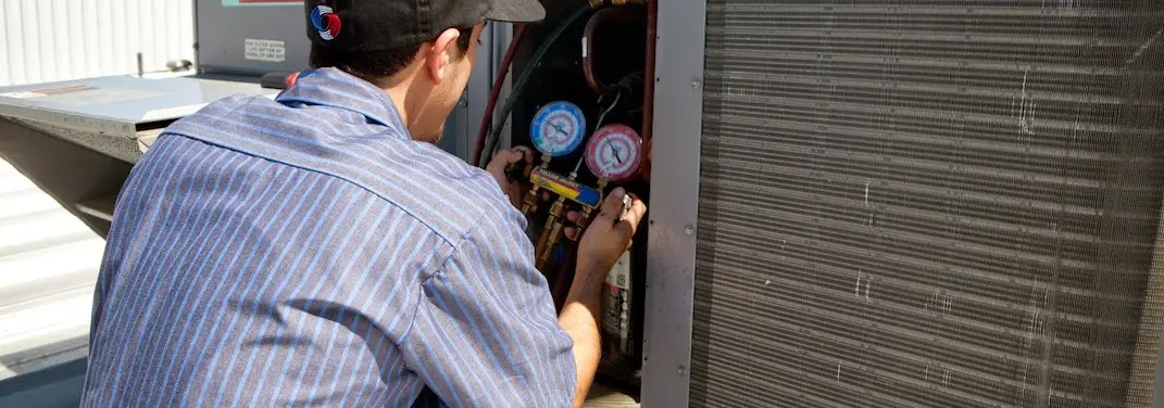 HVAC technician servicing a condenser unit in Cave Spring