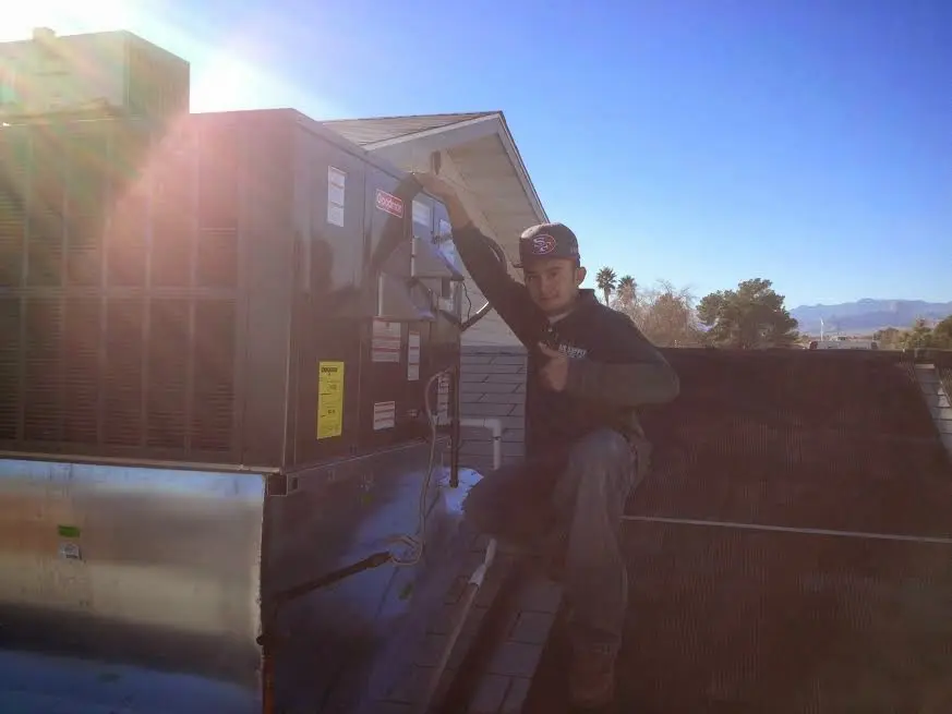 HVAC technician performing Boiler Repair on a rooftop unit in Cave Spring